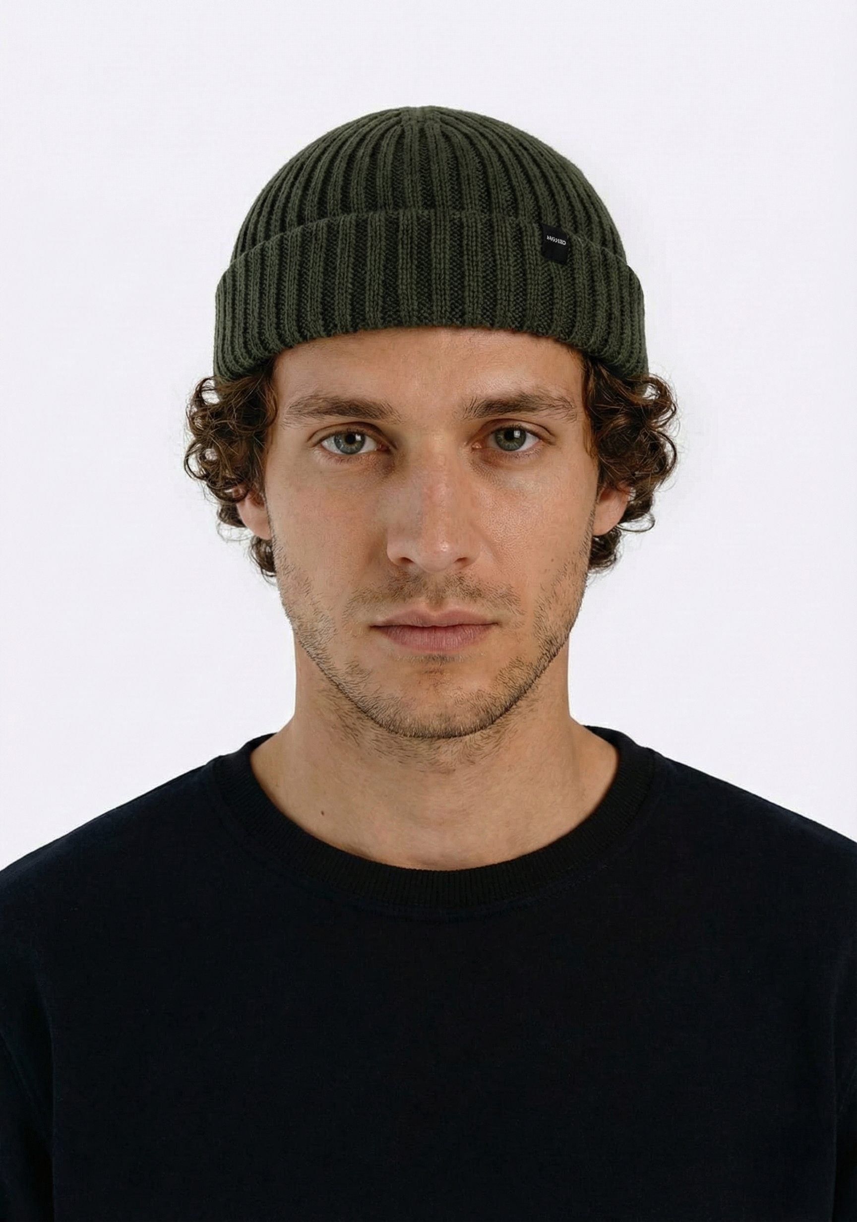 Man wearing a green beanie against a white background